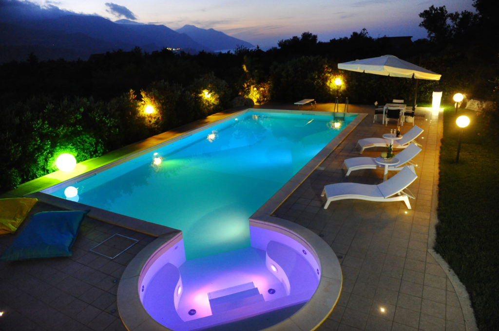 piscinas con piscina de noche con cascadas modernas y luces