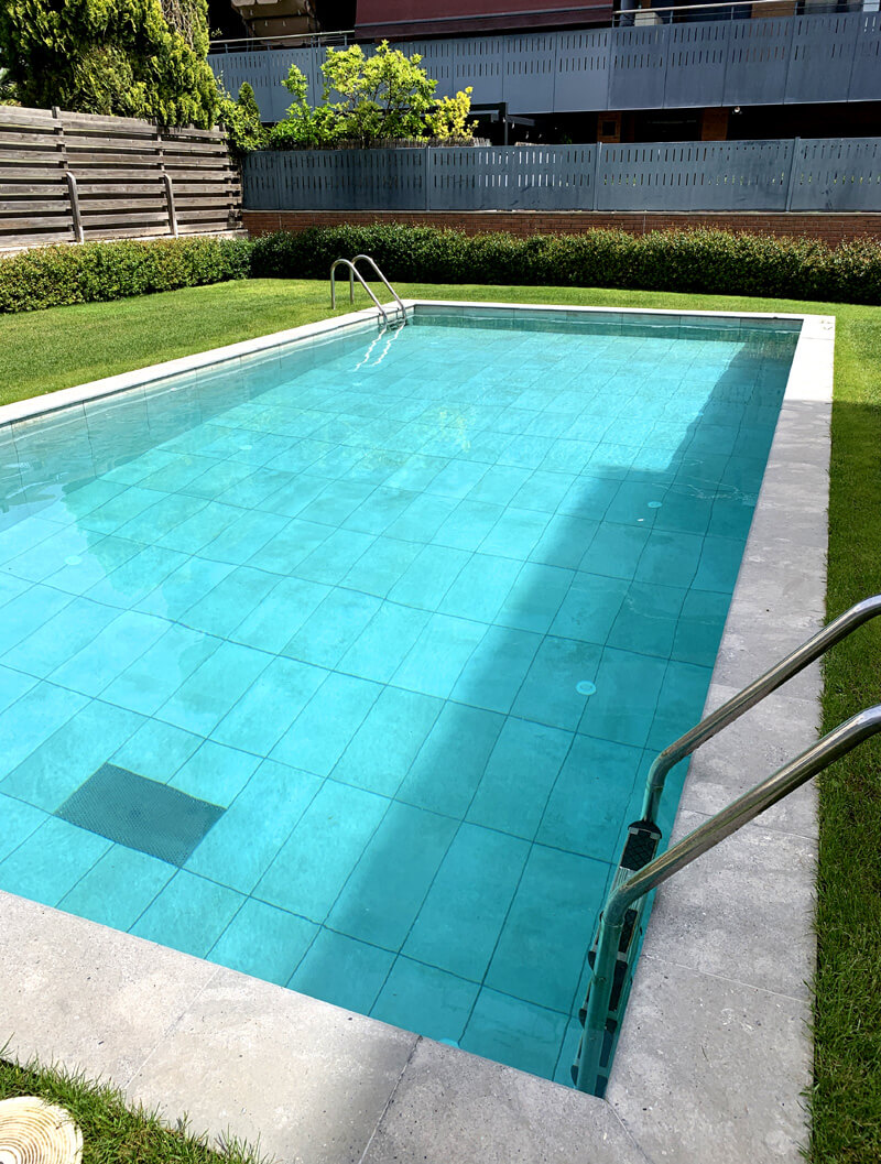 Piscina de obra rectangular con skimmer con revestimiento y borde piscina de porcelánico en Logroño