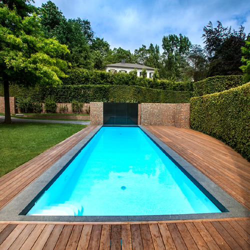 construcción e instalación de suelo piscina de madera en piscina de obra moderna rectangular larga y estrecha con cascada en jardín