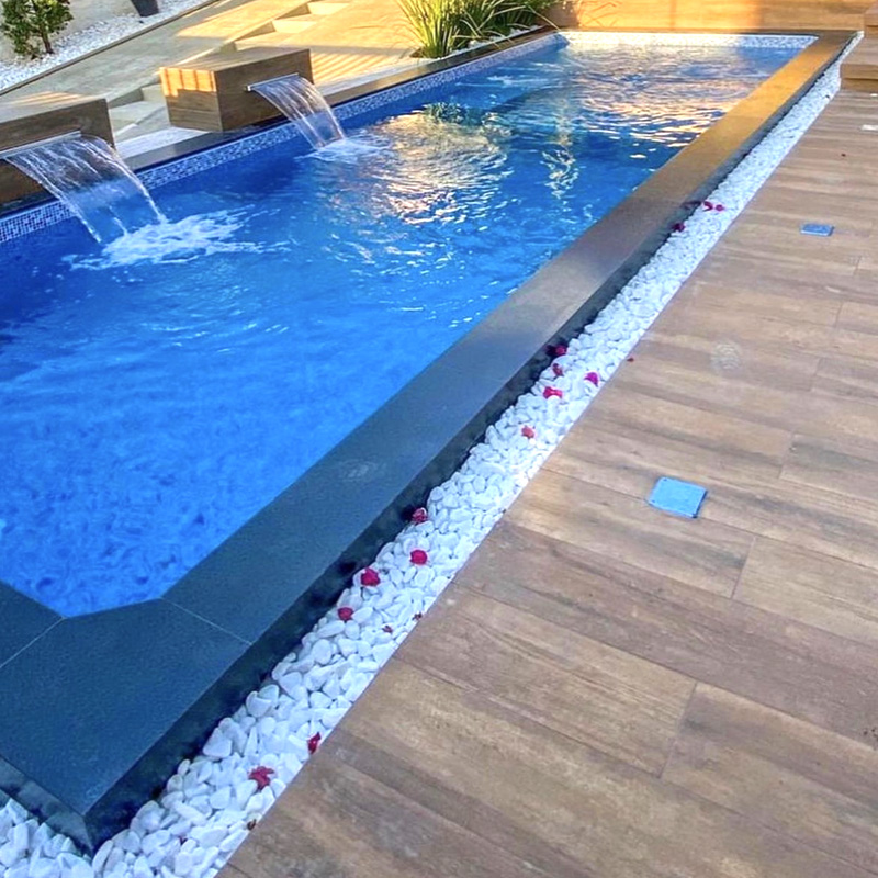 piscina arroyomolinos madrid larga y estrecha con cascadas de obra y revestimiento piscina gresite azulejo mosaico y suelo piscina porcelánico en casa modena