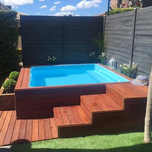 pequeño jardín con piscina prefabricada poliester elevada revestida de madera