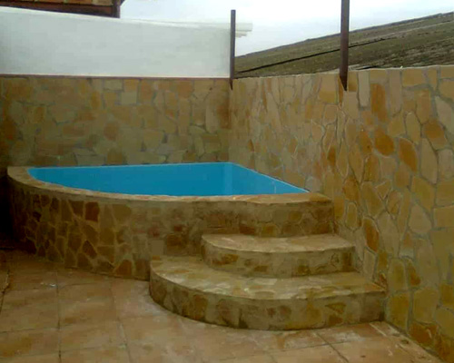 mini piscina elevada 2x2 rinconera de poliester y fibra de vidrio para rincon revestida en piedra y escalera de obra exterior