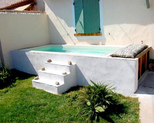 mini piscina ibicenca de fibra elevada rectangular reforzada con poliester revestida de muro de obra encalado de blanco Martina