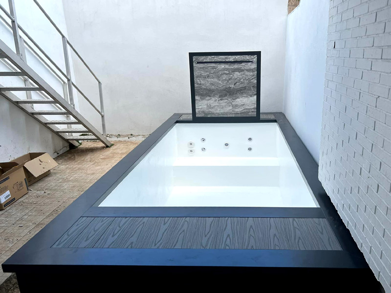 piscina prefabricada alta con banco jets de hidromasaje y  cascada piscina para terraza pequeña con mal acceso complicado