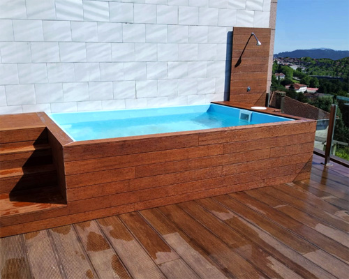 piscina prefabricada pequeña rectangular de poliester en alto Carmela con láminas de madera en ático
